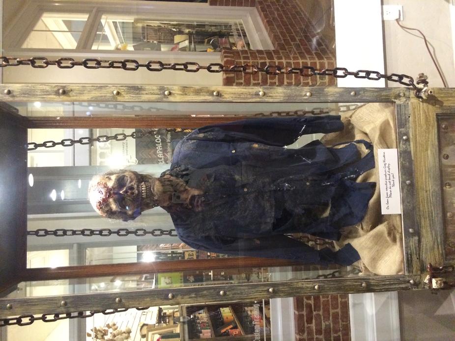 The zombie Greg nicotero donated to the museum in a glass and wooden case