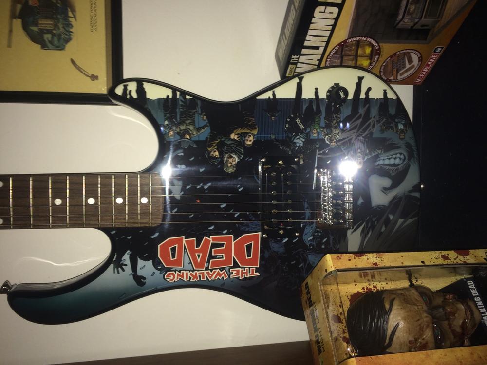 This piece is one of my favorites it is the limited edition walking dead guitar which Robert Kirkman signed as well