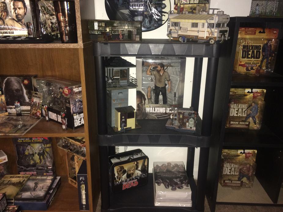 The walking dead 4 buildings sets, 10in Rick grimes figure, an extra lunch box the other two are in a different photo and twd compendium #1 and stack of comics